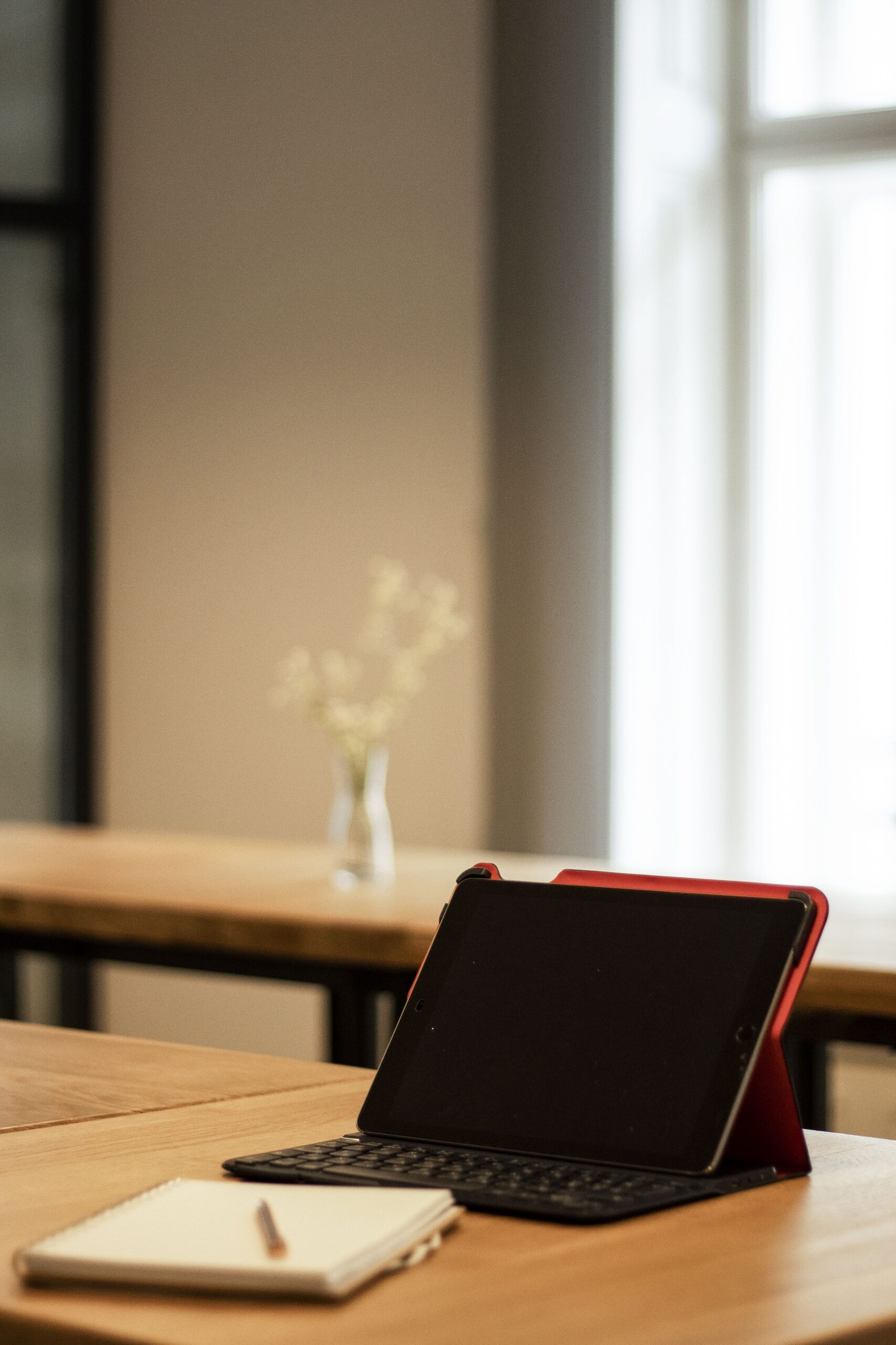 Warm and inviting workspace featuring a digital tablet and notebook on a wooden desk.